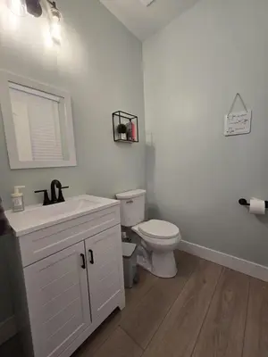 a white bathroom with a toilet and a sink at The Backwoods Paradise in Logan