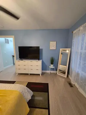 a bedroom with a flat screen tv on a blue wall at The Backwoods Paradise in Logan