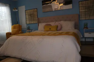 a bedroom with a large bed with a yellow pillow on it at The Backwoods Paradise in Logan