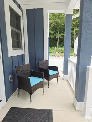 two chairs and a table on a porch at The Backwoods Paradise in Logan