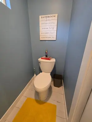 a bathroom with a toilet with a sign on the wall at The Backwoods Paradise in Logan
