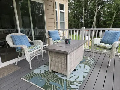 a patio with wicker chairs and a table on a porch at The Backwoods Paradise in Logan