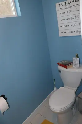 a bathroom with a toilet with a sign on the wall at The Backwoods Paradise in Logan