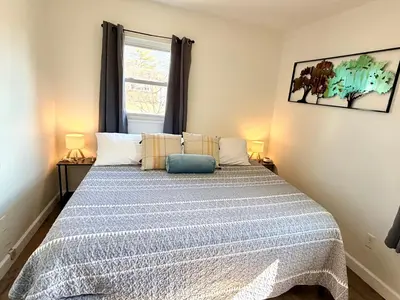 a bedroom with a bed with a blue pillow on it at Ranch-3 Bedroom-Pet & Kid-Fenced -EV Charging-King Bed in Gahanna