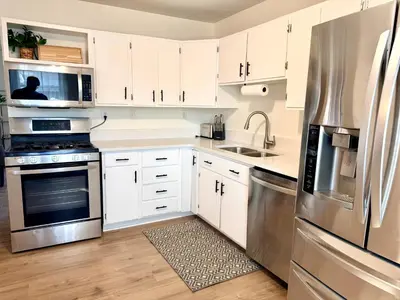 a kitchen with white cabinets and stainless steel appliances at Ranch-3 Bedroom-Pet & Kid-Fenced -EV Charging-King Bed in Gahanna