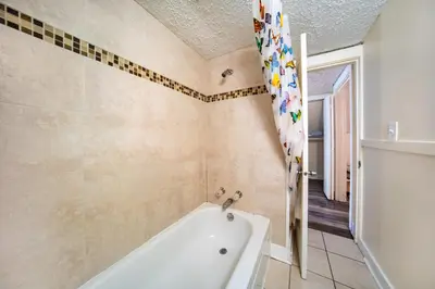 a bathroom with a white tub and a shower at Cuyahoga Falls 3 bedroom 2 bath in Cuyahoga Falls
