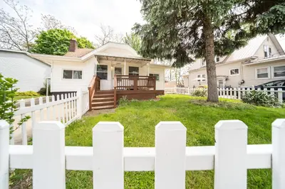 a white picket fence in front of a house at Cuyahoga Falls 3 bedroom 2 bath in Cuyahoga Falls