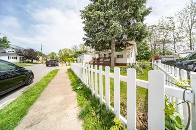a white picket fence next to a driveway at Cuyahoga Falls 3 bedroom 2 bath in Cuyahoga Falls