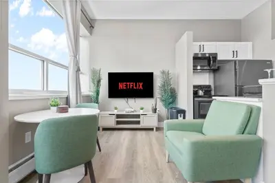 a living room with a tv and two chairs at 1BR • City View • Huntington • King Bed • 2 TVs in Cleveland