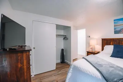 a bedroom with a bed and a flat screen tv at Grandma's Place - Steps from Downtown Sugarcreek in Sugarcreek
