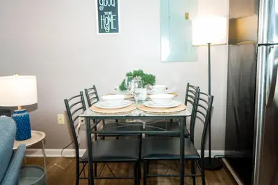 a dining room table with chairs and a table with dishes on it at Little Peaceful Loft in Cleveland