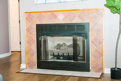 a fireplace in a living room with a tiled wall at Little Peaceful Loft in Cleveland
