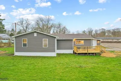 a house with a deck on a yard at Corporate Cottage on Circle in Thornville