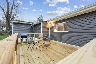 a patio with two chairs and a table on a deck at Corporate Cottage on Circle in Thornville