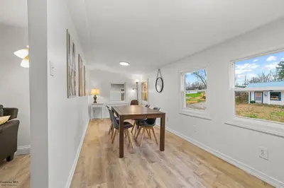 a dining room and living room with a table and two windows at Corporate Cottage on Circle in Thornville