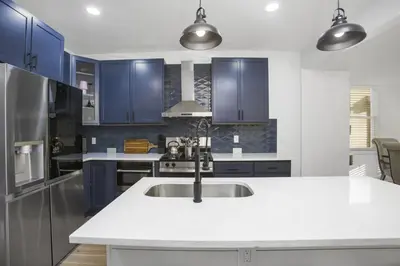 a kitchen with blue cabinets and a sink at Victorian Villa in Columbus