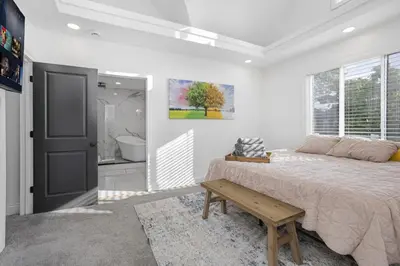 a bedroom with a bed and a bench next to a window at Victorian Villa in Columbus