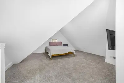 a attic bedroom with a bed and a tv at Victorian Villa in Columbus