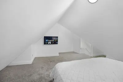 a white room with a bed and a picture on the wall at Victorian Villa in Columbus