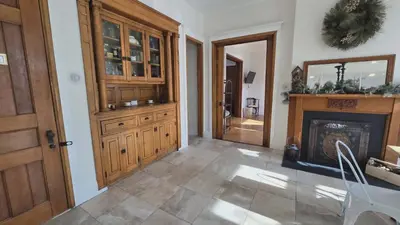 a living room with a fireplace and wooden cabinets at Lincoln House Inn in Bowling Green