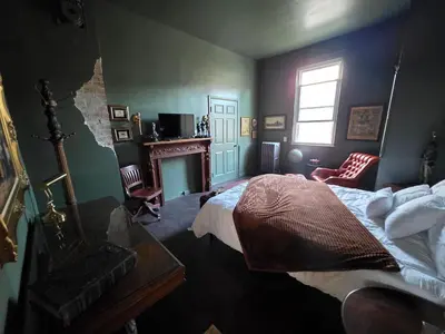 a bedroom with a bed and a fireplace and a window at Lincoln House Inn in Bowling Green