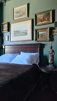 a bedroom with a bed and paintings on the wall at Lincoln House Inn in Bowling Green