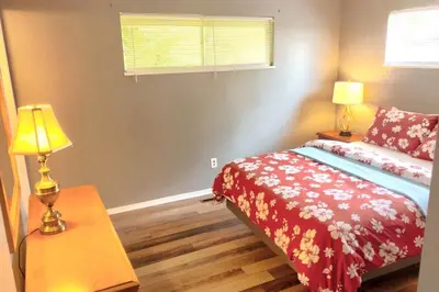 a bedroom with a bed and a table with a lamp at 3BR Home, Pet-Friendly, Fenced Yard Near I-70, I-75, Hospitals, Wright-Patt AFB in Dayton