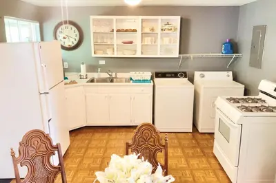 a kitchen with white cabinets and white appliances at 3BR Home, Pet-Friendly, Fenced Yard Near I-70, I-75, Hospitals, Wright-Patt AFB in Dayton