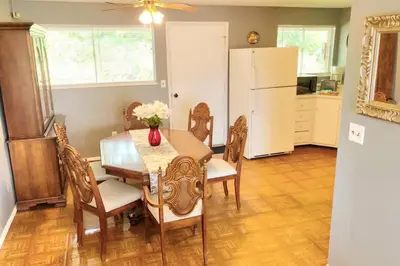 a dining room with a table and chairs and a refrigerator at 3BR Home, Pet-Friendly, Fenced Yard Near I-70, I-75, Hospitals, Wright-Patt AFB in Dayton