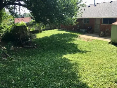 a yard with a large shadow of a tree at 3BR Home, Pet-Friendly, Fenced Yard Near I-70, I-75, Hospitals, Wright-Patt AFB in Dayton