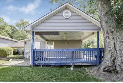 a house with a blue fence and a tree at Quaint Cottage in Thornville