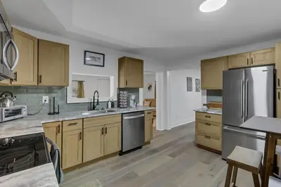 a kitchen with wooden cabinets and a stainless steel refrigerator at Mirror Pond Cabins in Rockbridge