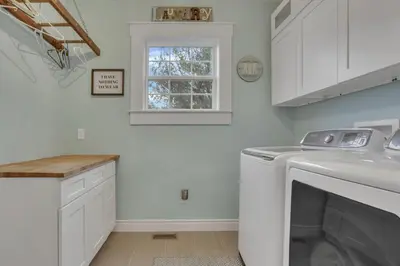 a white laundry room with a washer and a window at The Lakehouse in Buckeye Lake