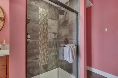 a glass shower in a bathroom with pink walls at The Lakehouse in Buckeye Lake
