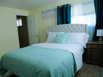a bedroom with a large bed with blue curtains and a window at A Nice and Cozy Home in Fairborn in Fairborn