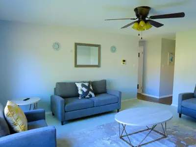 a living room with blue furniture and a ceiling fan at A Nice and Cozy Home in Fairborn in Fairborn