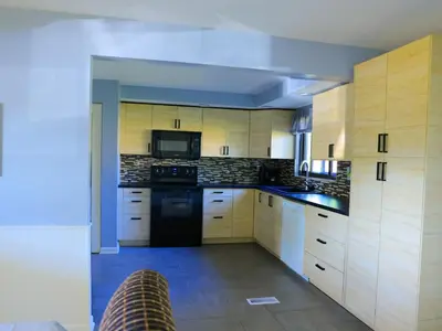 a kitchen with wooden cabinets and black appliances at A Nice and Cozy Home in Fairborn in Fairborn