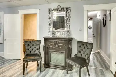 a room with a fireplace and two chairs and a mirror at Canton Condo Near Football Hall of Fame and Dtwn! in Canton