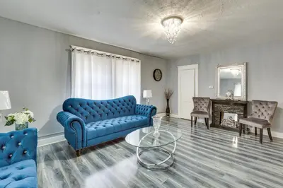 a living room with a blue couch and a glass table at Spacious Condo 4 Mi to Pro Football Hall of Fame! in Canton