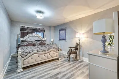 a bedroom with a bed and a chair and a lamp at Spacious Condo 4 Mi to Pro Football Hall of Fame! in Canton