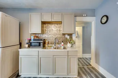 a kitchen with white cabinets and a sink and a microwave at Spacious Condo 4 Mi to Pro Football Hall of Fame! in Canton