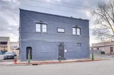 a blue brick building with a door on a street at Spacious Condo 4 Mi to Pro Football Hall of Fame! in Canton