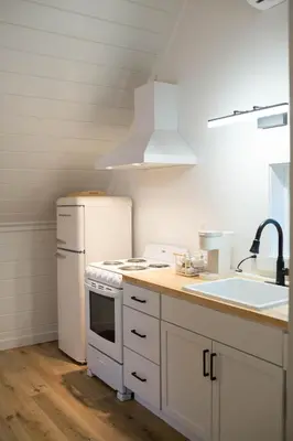 a kitchen with a white refrigerator and a sink at Liv's Treehouse-Honeymoon Suite-Hot Tub in Milroy