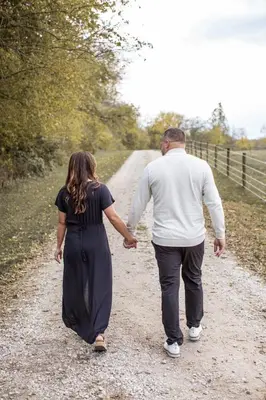 a man and woman walking down a dirt road holding hands at Liv's Treehouse-Honeymoon Suite-Hot Tub in Milroy