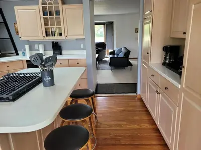 a kitchen with a white counter and stools in a kitchen at Perrysburg On The River in Perrysburg