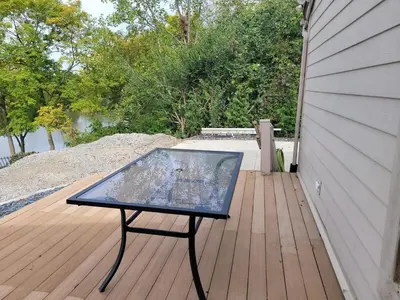 a glass table sitting on top of a wooden deck at Perrysburg On The River in Perrysburg