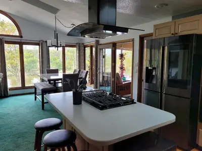 a kitchen with a white counter with a stove top island at Perrysburg On The River in Perrysburg