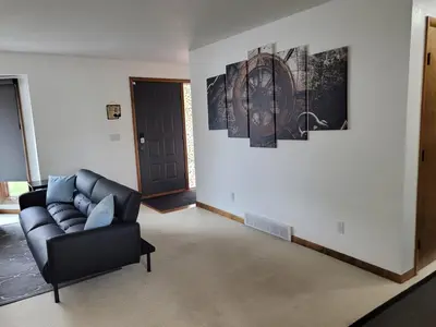 a living room with a couch and paintings on the wall at Perrysburg On The River in Perrysburg