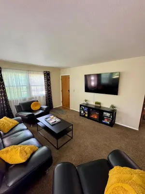 a living room with couches and a flat screen tv at The Creekside Oasis Duplex - Central Avon in Avon