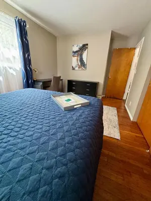 a bedroom with a bed with a blue comforter at The Creekside Oasis Duplex - Central Avon in Avon
